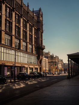 A serene city street lined with historic buildings under a clear blue sky.