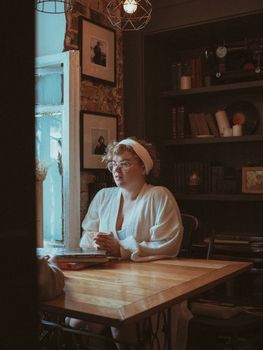 Cozy scene of a woman reading by a window in a vintage library setting.. cozy, scene, woman