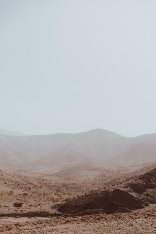 Free Serene view of vast desert dunes under a hazy sky, capturing tranquil natural beauty. Stock Photo
