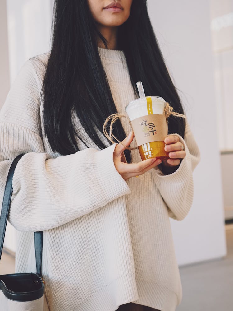 Woman In White Sweater Holding A Cup Of Drink