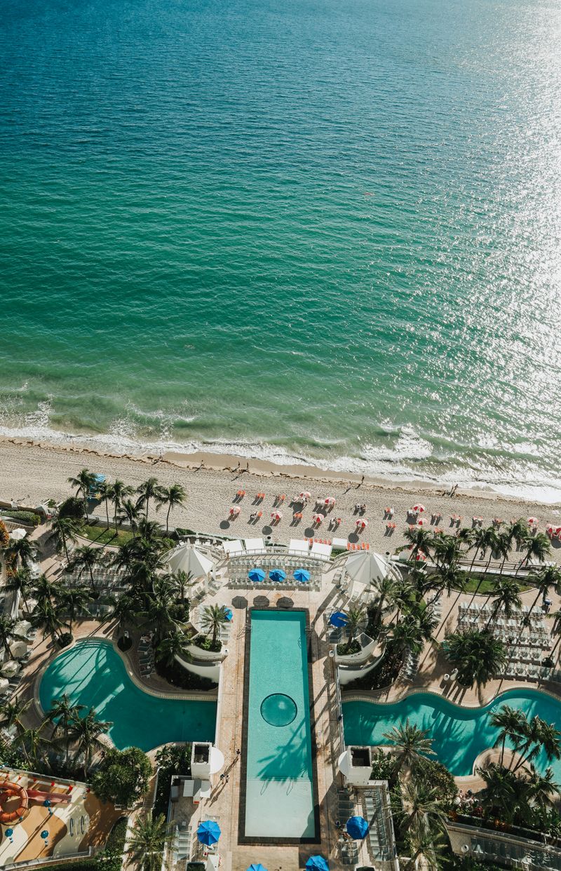 Aerial view of a beachfront resort with pools