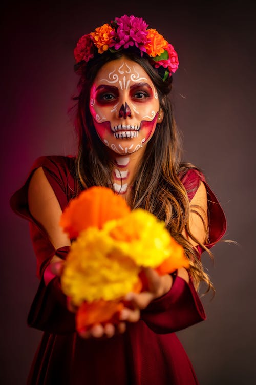 A Woman with Face Paint Holding Flowers