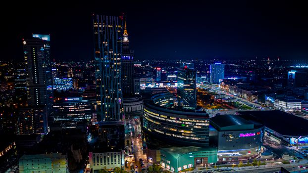 Vibrant cityscape of Warsaw, Poland, captured at night showcasing modern architecture and bright city lights.