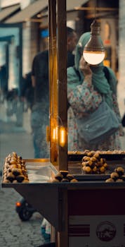 Charming street food scene in Istanbul with roasted chestnuts and people passing by, captured at dusk.
