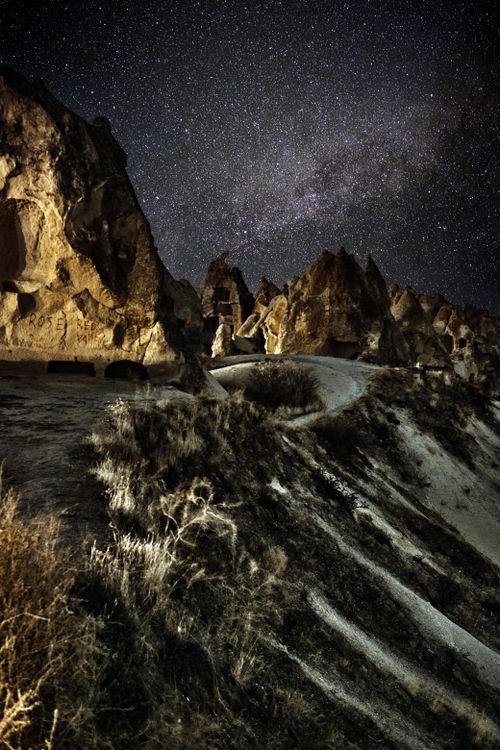 Free Stunning night view of Cappadocia's unique rock formations under a starry sky. Stock Photo
