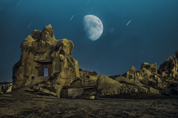 Long Exposure Photo Of Moon And Starry Sky Above Rocks In Desert