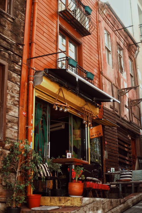 Free Cozy rustic cafe entrance with outdoor seating in a vibrant urban street. Stock Photo