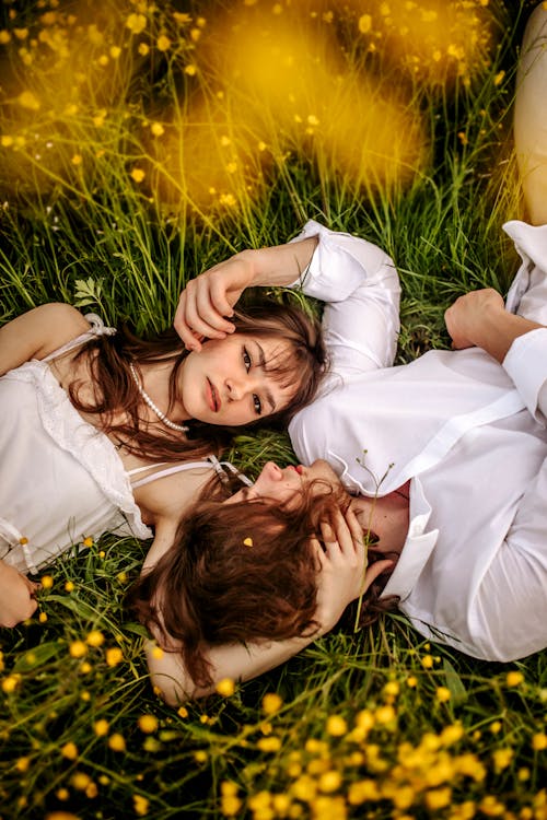 Free Couple Lying in Field of Yellow Flowers Stock Photo