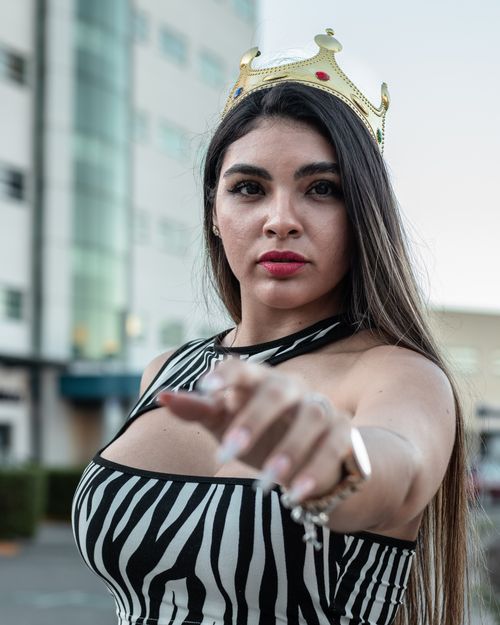 Free Close-up of a woman in a crown, with a confident gesture outdoors. Stock Photo