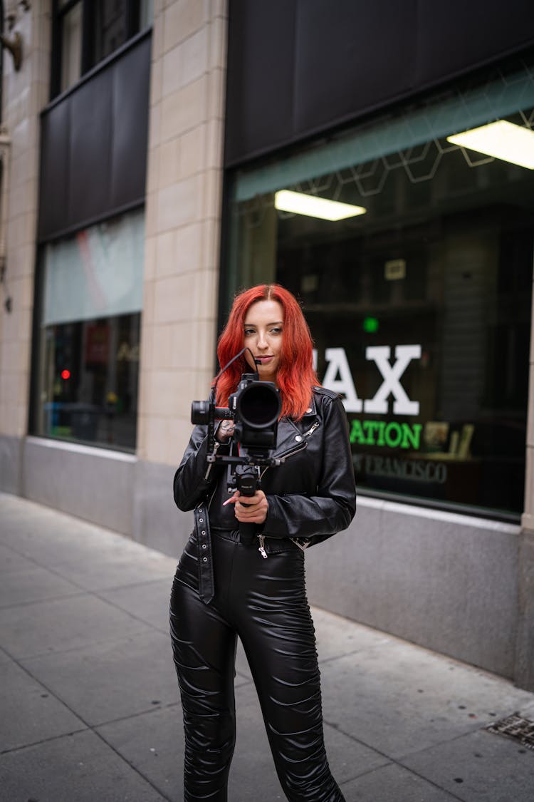 Woman With Professional Camera Filming On Street