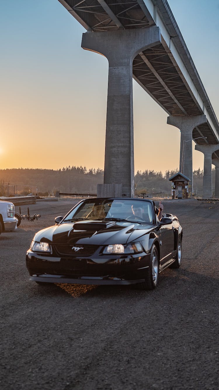 Man Driving A Black Convertible Ford Mustang 