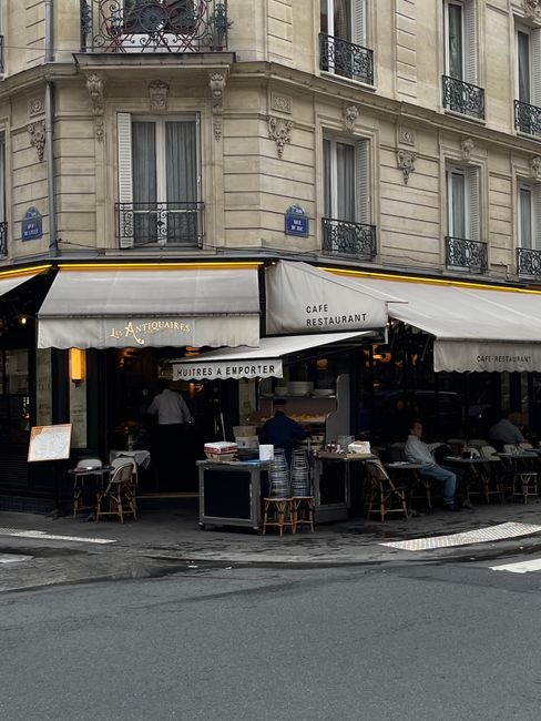 Outdoor view of a bustling corner café in Paris, capturing authentic European urban life.