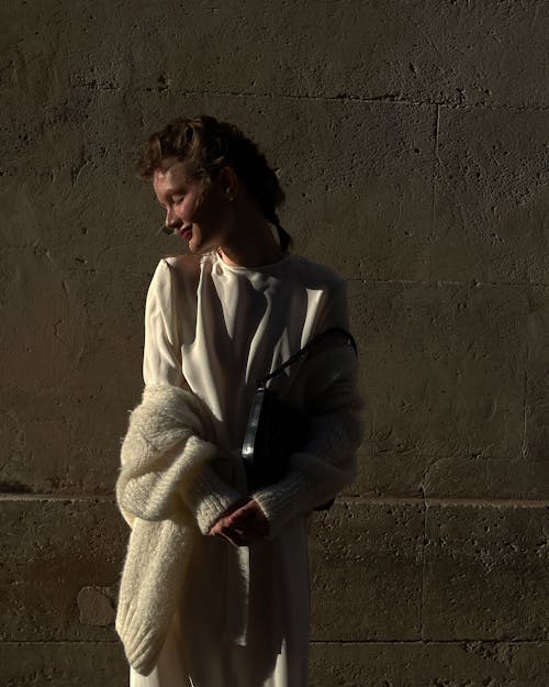 Elegant Woman Posing near Wall in Shadow