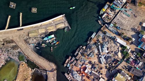 Free Aerial imagery capturing the bustling harbor in Jakarta's Penjaringan district, showcasing boats and industrial activity. Stock Photo