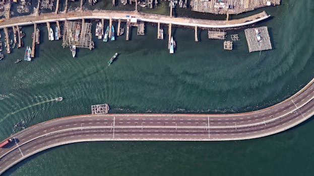 从空中俯瞰雅加达海滨，蜿蜒的高速公路和码头旁停泊着渔船