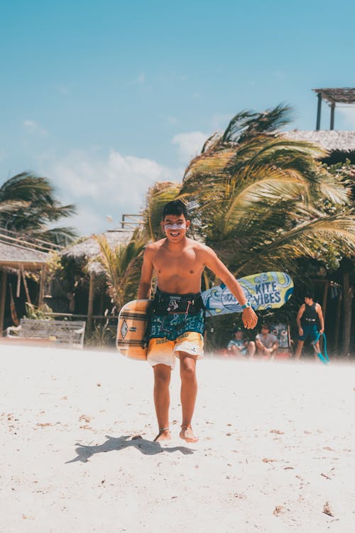 Young Man Holding a Wakeboard on the Beach 