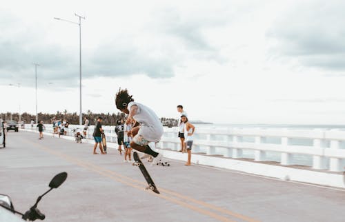 Man Doing a Trick on a Skateboard on a Promenade with View of a Sea 