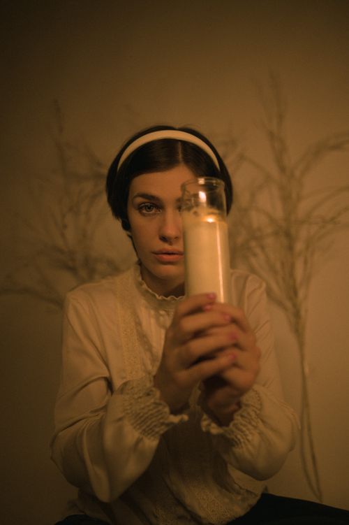 Free A woman holds a candle, creating a vintage candlelit ambiance. Stock Photo