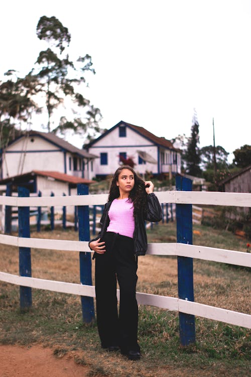 A Woman Leaning on Wooden Fence