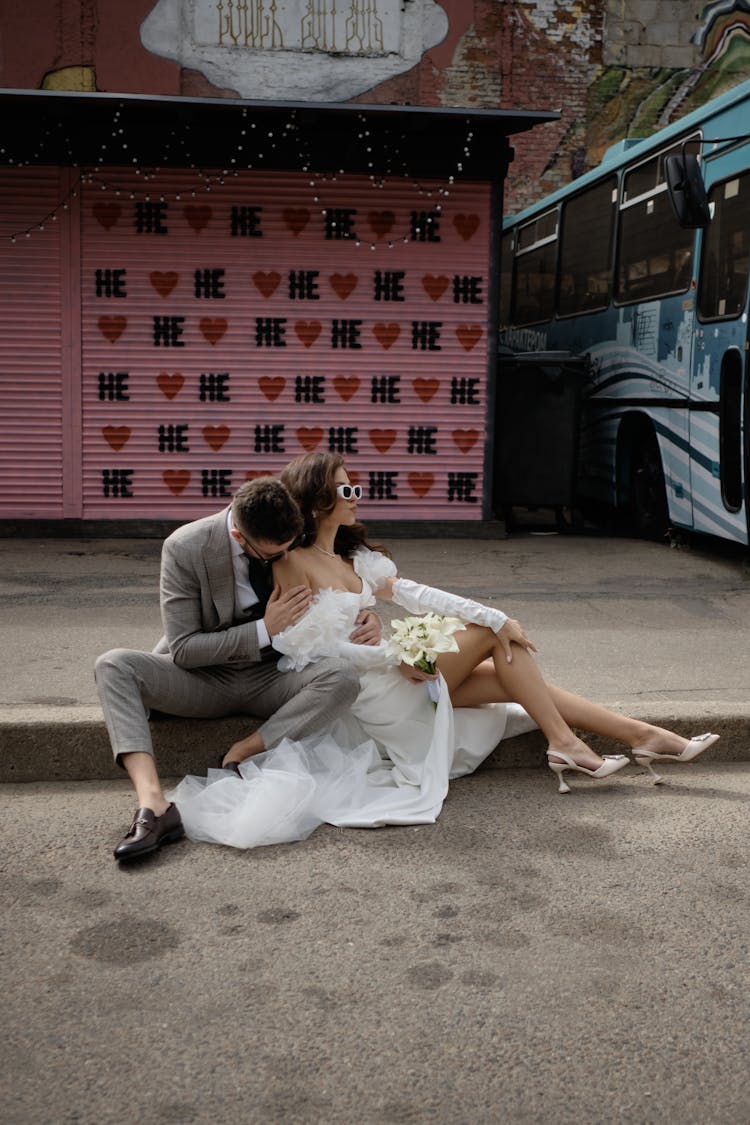 Bride And Groom Sitting On Gutter