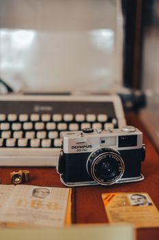 Retro styled analog camera alongside a classic typewriter indoors.