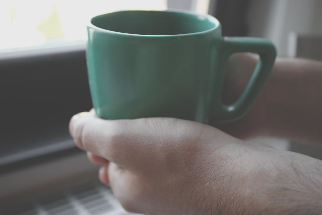 Persona In Possesso Di Tazza Verde