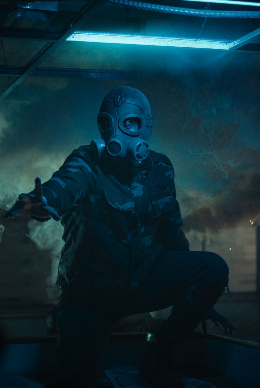 Masked figure crouching in a smoke-filled ruin — photo by Fernando Paleta on Pexels