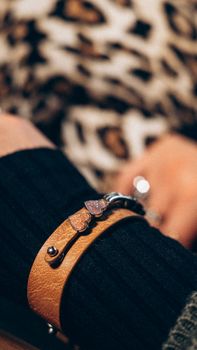 Close-up of a fashionable leather bracelet with heart decorations, perfect for a chic accessory look.