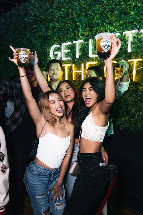 Women Rising Beer Cups at Party