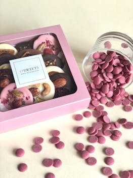 A delightful selection of gourmet chocolates in a pink box with elegant presentation.
