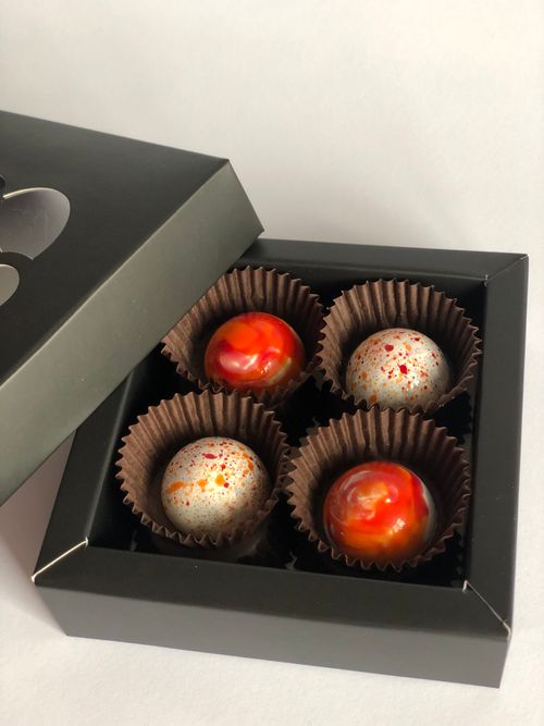 Free Four gourmet chocolates in a luxurious box, perfect for gifting and special occasions. Stock Photo