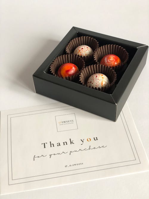 Close-up of a Box of Chocolate Pralines and a Thank You Card 