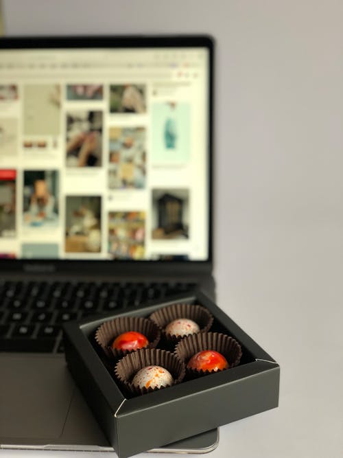 A Box of Chocolate Pralines Standing on a Laptop 