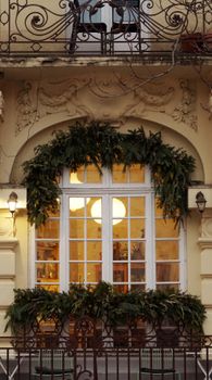 Elegant facade with festive greenery, ornate design, and warm window lighting.