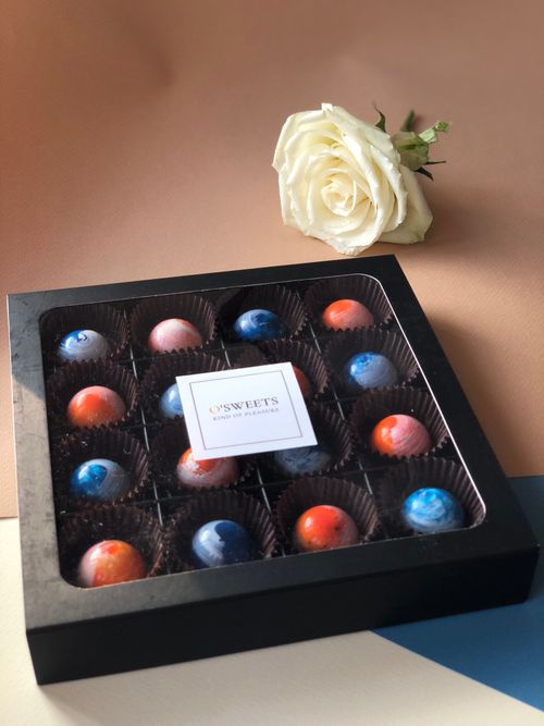 Free Stylish box of assorted chocolates next to a white rose, perfect as a gourmet gift. Stock Photo