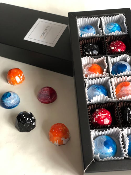 Fotos de stock gratuitas de bombones de mármol, caja negra, colorido