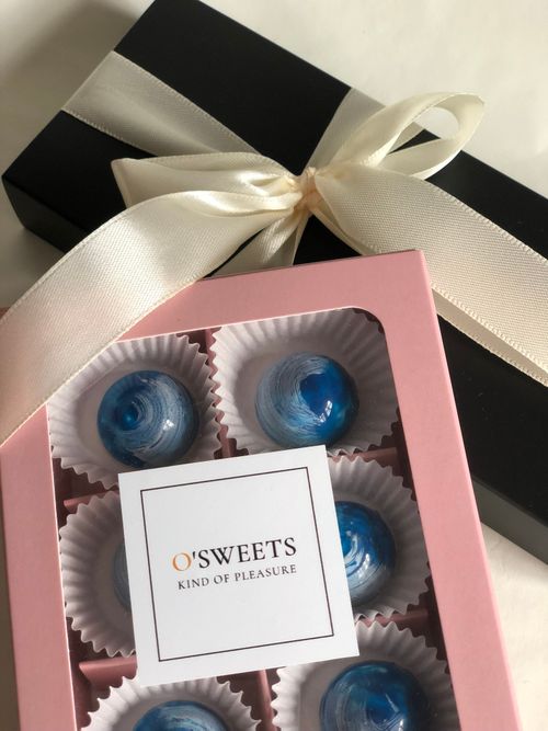 Free A stylish gift box with sweets, featuring pink and black packaging and a decorative ribbon. Stock Photo