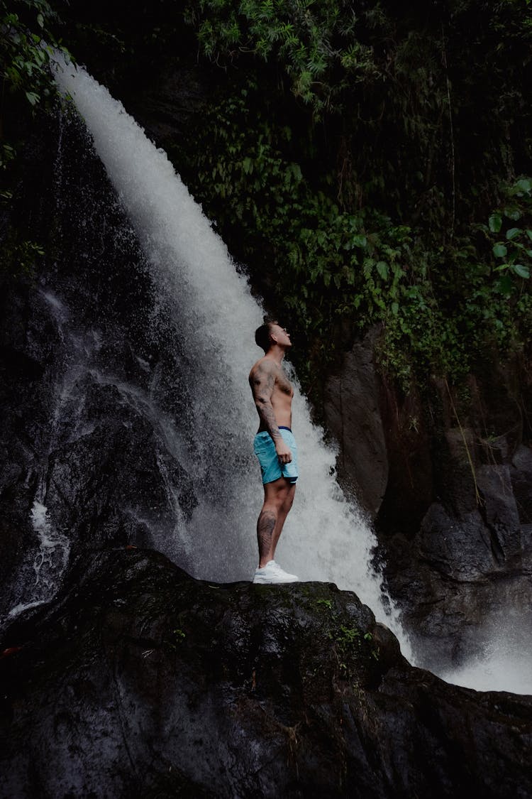 Man Enjoying Roar Of Waterfall