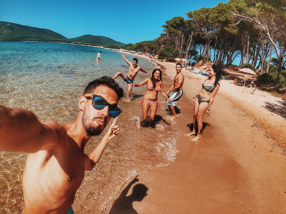 Group Of People Standing On Beach Shore