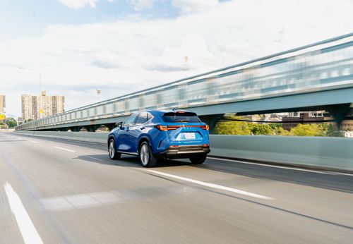 Free A blue SUV speeds across an urban bridge on a sunny day. Stock Photo