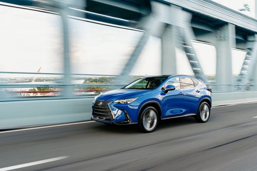 Free A dynamic shot of a blue SUV driving fast on a city bridge, showcasing motion and speed. Stock Photo