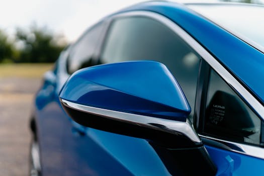 Detailed shot of a blue car's side mirror with a sleek design.