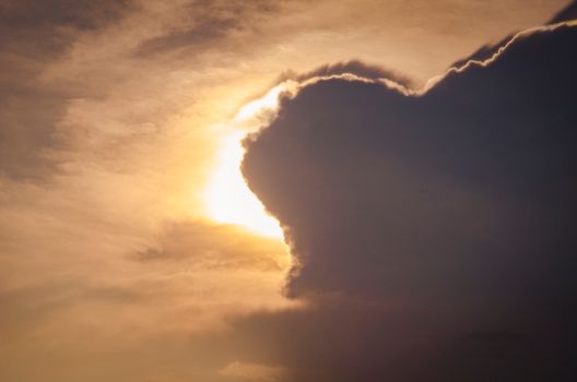 A stunning silhouette of clouds with a backlit golden sun during sunset. Perfect for dramatic visuals.