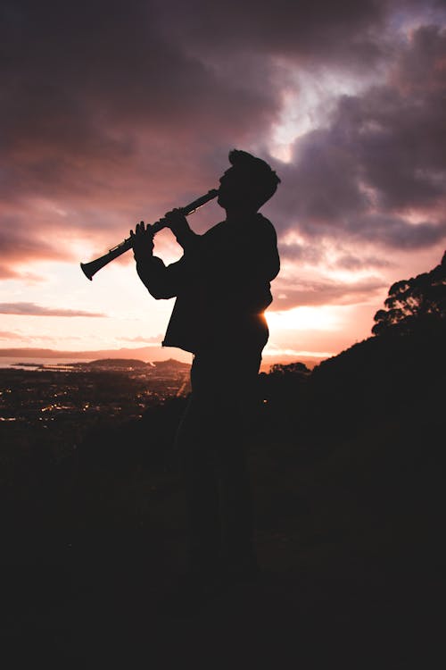 Silhouette Photo Of Person Playing Clarinet