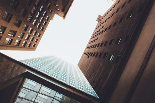 Free Low angle view of modern skyscrapers forming a dramatic urban skyline under a bright sky. Stock Photo