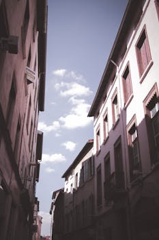 在蓝天的背景下，狭窄的城市小巷透出历史建筑的景象