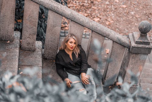 Woman in Black Long Sleeve Shirt Sitting on Stairs