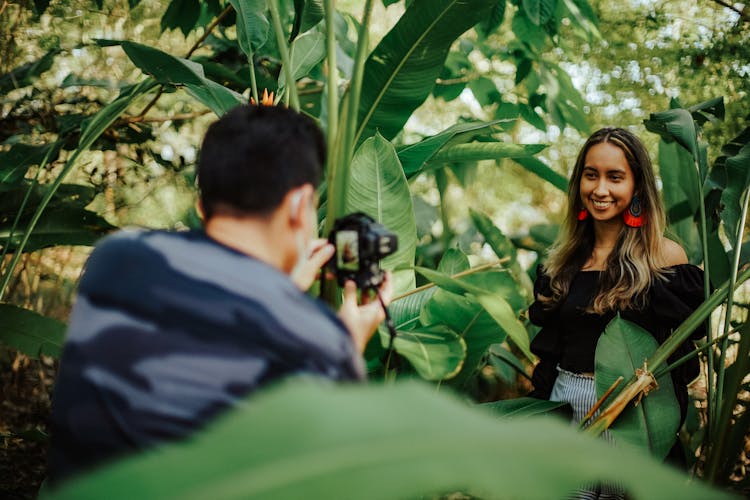 Photographer Taking Photo Of Woman In Forest