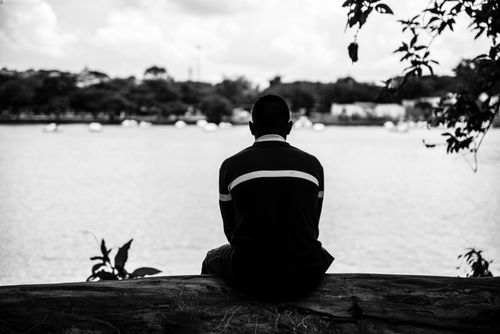 Free A solitary figure sits by the lake in São Paulo, captured in striking black and white. Stock Photo