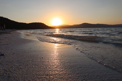 altın rengi Güneş, beyaz kum, deniz içeren Ücretsiz stok fotoğraf
